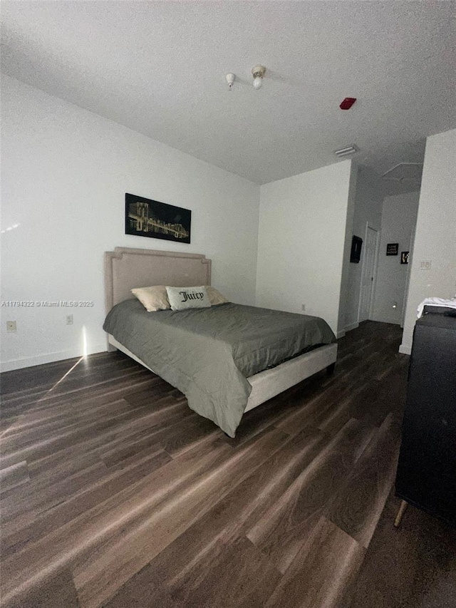 bedroom featuring baseboards, visible vents, and wood finished floors