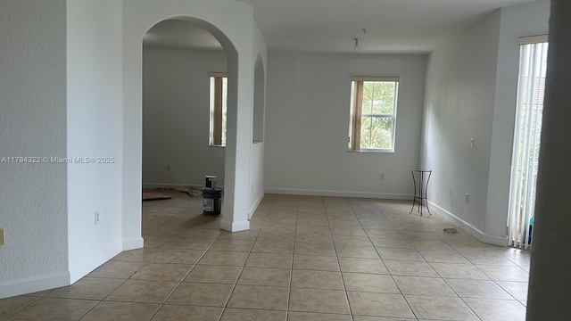 unfurnished room featuring light tile patterned floors and baseboards