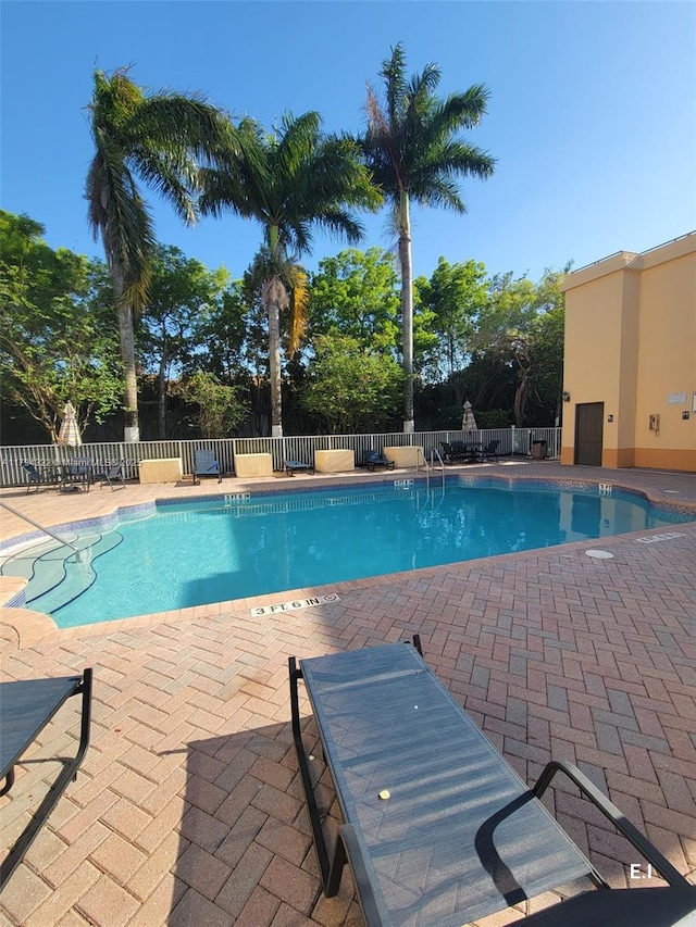 community pool featuring a patio and a fenced backyard