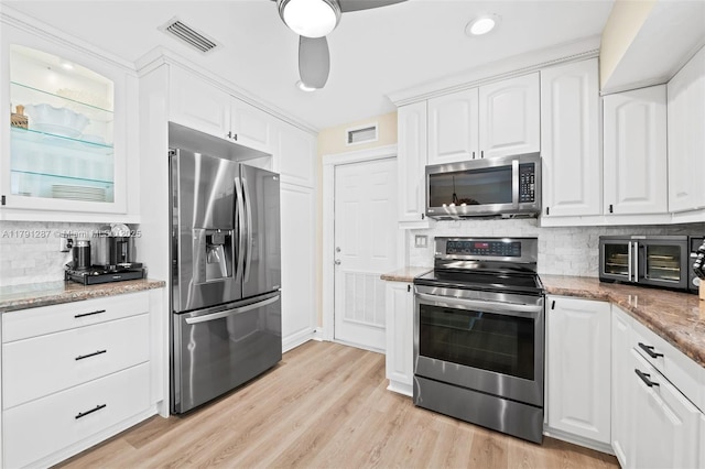 kitchen featuring visible vents, white cabinets, tasteful backsplash, and stainless steel appliances