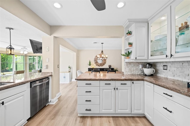 kitchen featuring a peninsula, white cabinetry, tasteful backsplash, ceiling fan with notable chandelier, and dishwasher