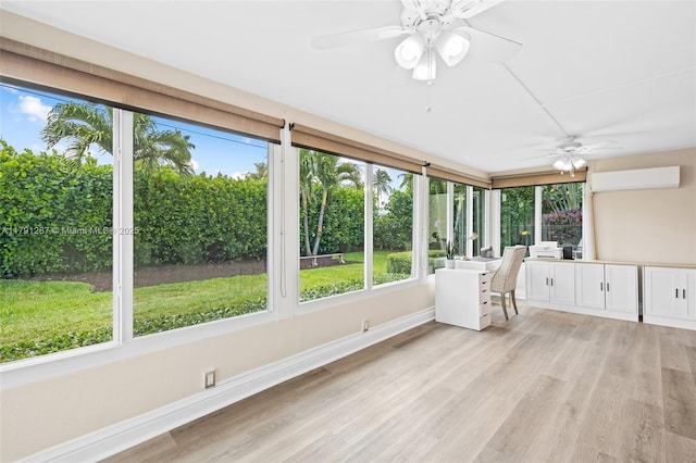 sunroom with baseboards, an AC wall unit, and wood finished floors