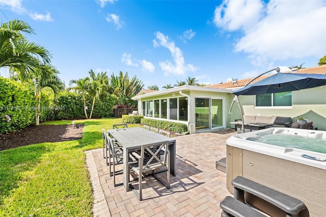 view of patio / terrace featuring outdoor dining area, a hot tub, and a sunroom