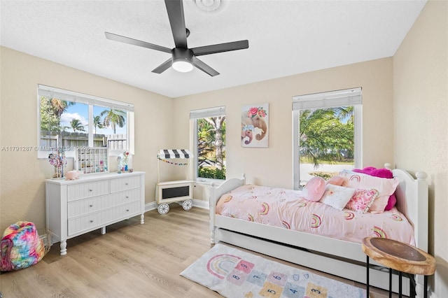 bedroom featuring a ceiling fan, baseboards, and wood finished floors