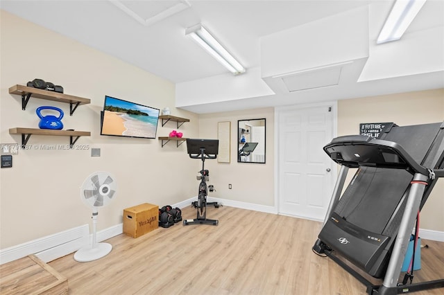 workout room with baseboards, attic access, and wood finished floors