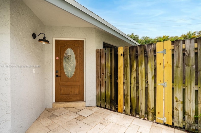 563 Lakeside Cir, Sunrise, FL 33326 - view of exterior entry featuring a gate, stucco siding, and fence
