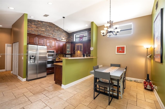 563 Lakeside Cir, Sunrise, FL 33326 - kitchen with stainless steel appliances, a peninsula, stone tile floors, hanging light fixtures, and high vaulted ceiling