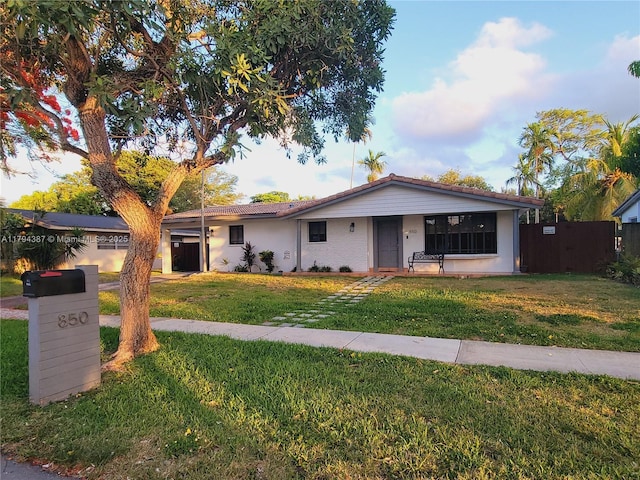 850 NE 182nd Ter, North Miami Beach, FL 33162 - view of front facade with fence and a front yard