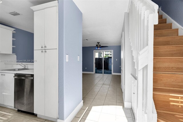 interior space featuring a sink, baseboards, light tile patterned floors, visible vents, and stairway