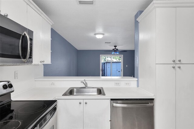 kitchen with a sink, light countertops, ceiling fan, and stainless steel appliances