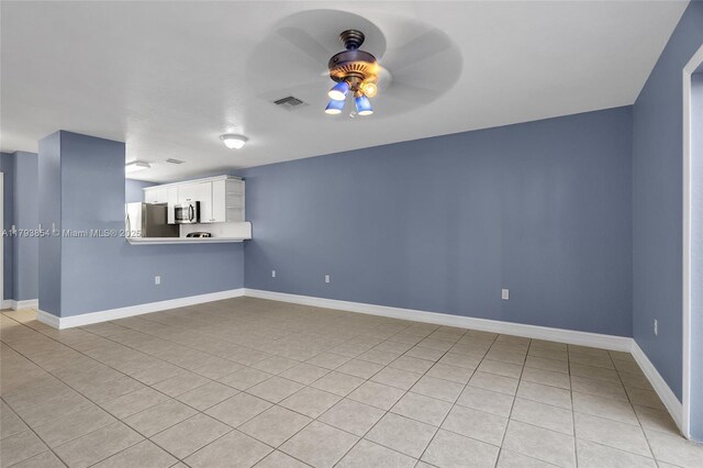 unfurnished living room with a ceiling fan, baseboards, visible vents, and light tile patterned floors
