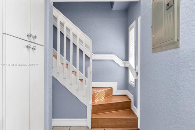stairs with baseboards and a textured wall