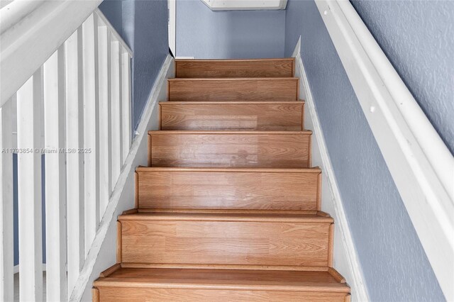 stairs featuring a textured wall