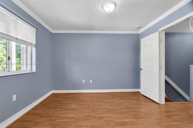 interior space featuring crown molding, baseboards, and wood finished floors