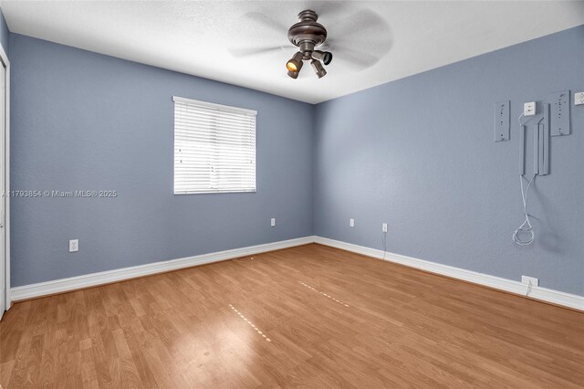unfurnished room featuring baseboards, a ceiling fan, and wood finished floors