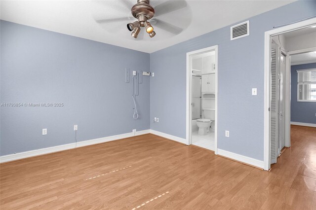 unfurnished bedroom with visible vents, light wood-style floors, ensuite bathroom, baseboards, and a ceiling fan