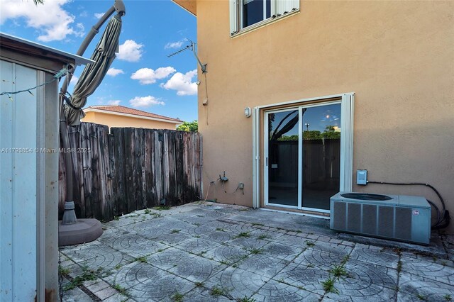 view of patio featuring central AC and fence