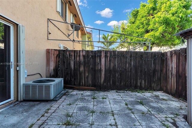 view of patio / terrace featuring fence and central AC unit
