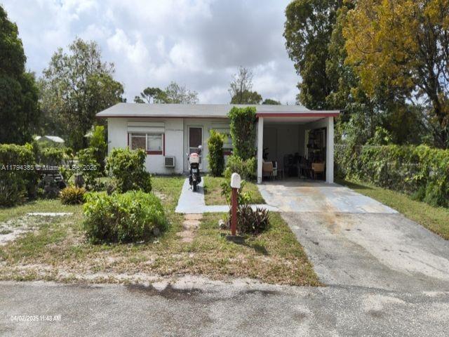 view of front of house featuring concrete driveway and a carport