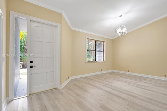 foyer entrance featuring baseboards, ornamental molding, light wood-style flooring, and a chandelier