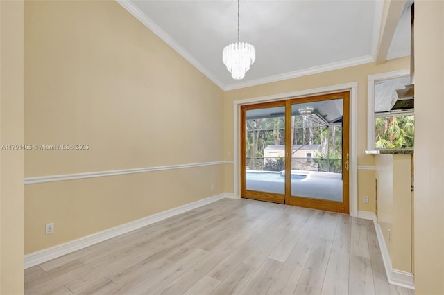 interior space with an inviting chandelier, baseboards, crown molding, and light wood-style floors