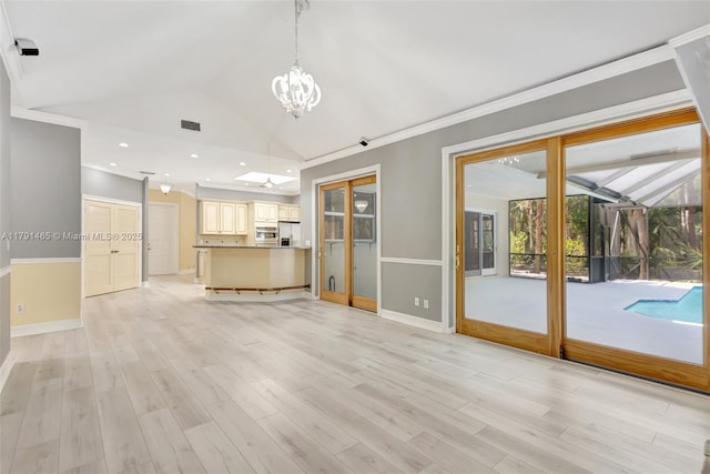 16789 98th Way N, Jupiter, FL 33478 - unfurnished living room with a chandelier, baseboards, light wood finished floors, lofted ceiling, and ornamental molding