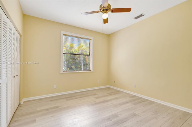 unfurnished bedroom featuring baseboards, visible vents, light wood finished floors, and a closet