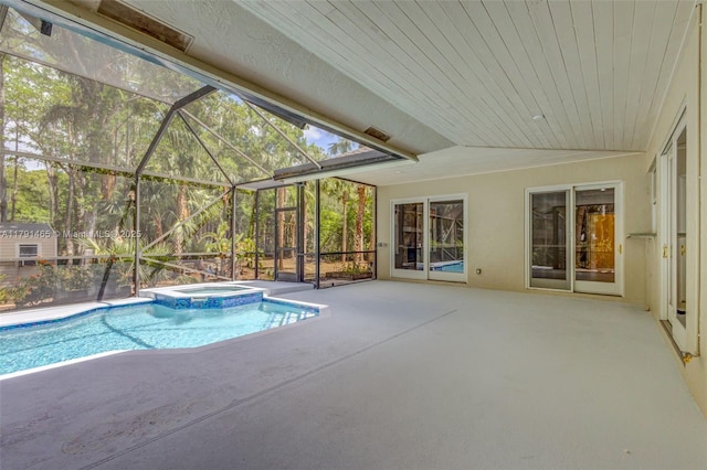 view of pool featuring a patio, glass enclosure, and a pool with connected hot tub