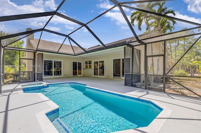 view of pool with glass enclosure, a pool with connected hot tub, and a patio area