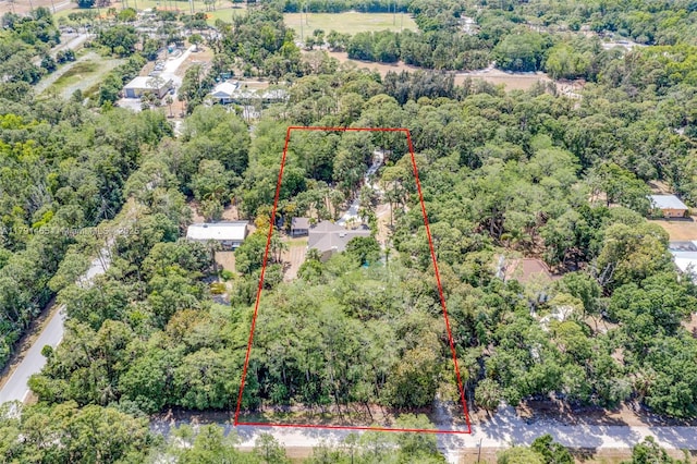 birds eye view of property featuring a forest view