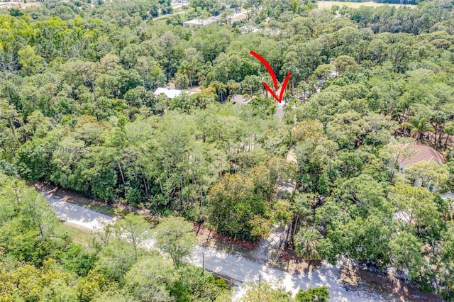 birds eye view of property featuring a wooded view