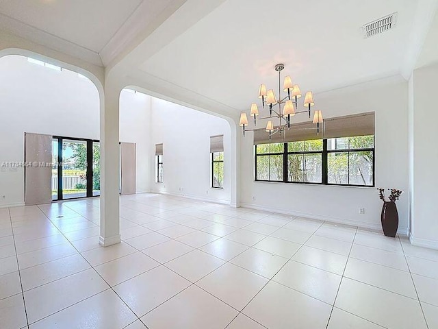 spare room with visible vents, a notable chandelier, and a wealth of natural light