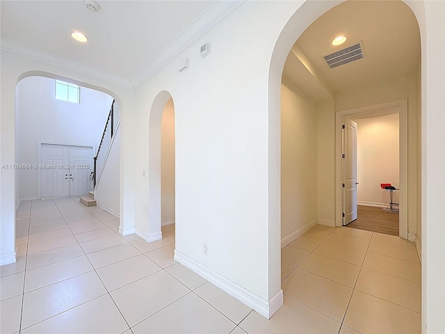 hall featuring visible vents, crown molding, recessed lighting, arched walkways, and light tile patterned floors