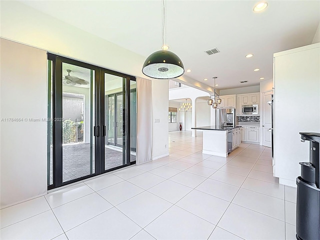 interior space featuring light tile patterned floors, arched walkways, recessed lighting, and visible vents