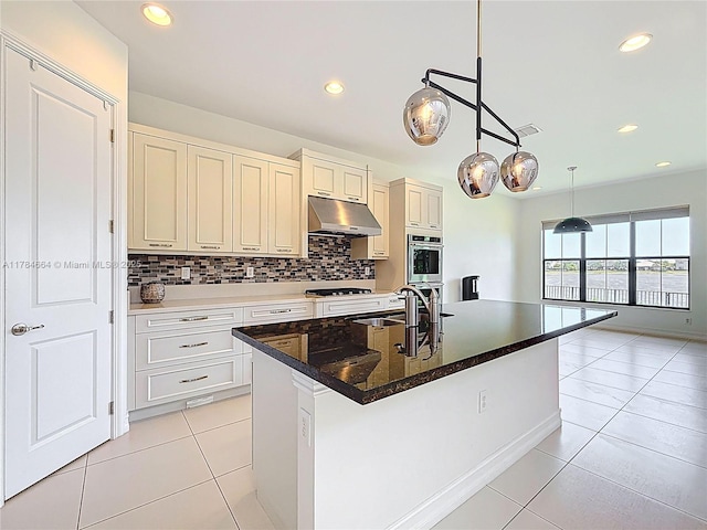kitchen with backsplash, visible vents, hanging light fixtures, gas stovetop, and under cabinet range hood