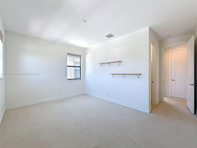 unfurnished room with light colored carpet, baseboards, and visible vents