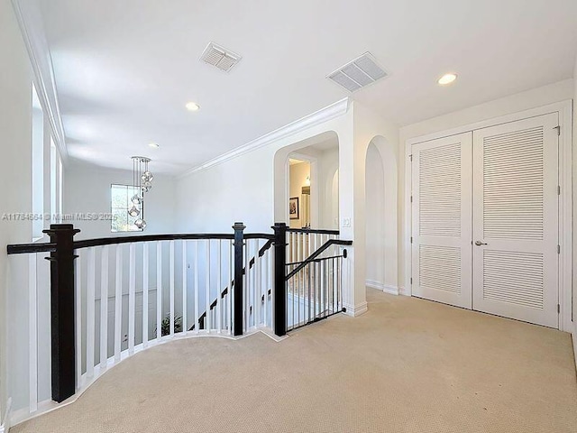 hallway featuring crown molding, an upstairs landing, carpet, and visible vents