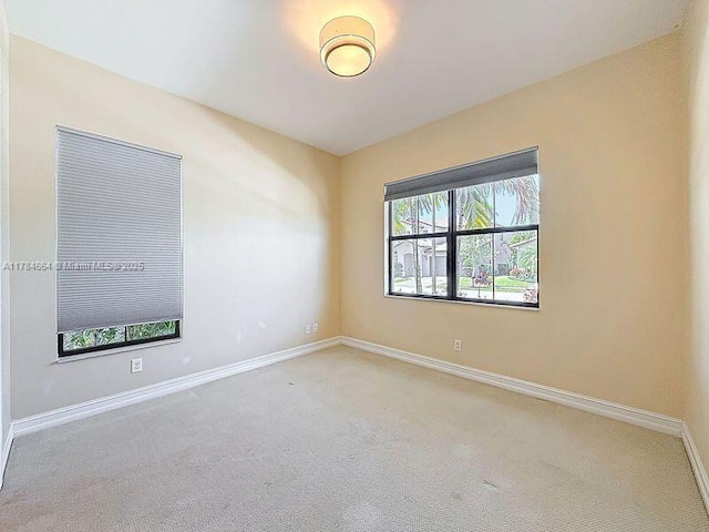 carpeted spare room with baseboards
