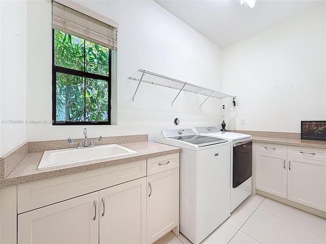 laundry area featuring a sink, light tile patterned floors, washing machine and dryer, and cabinet space