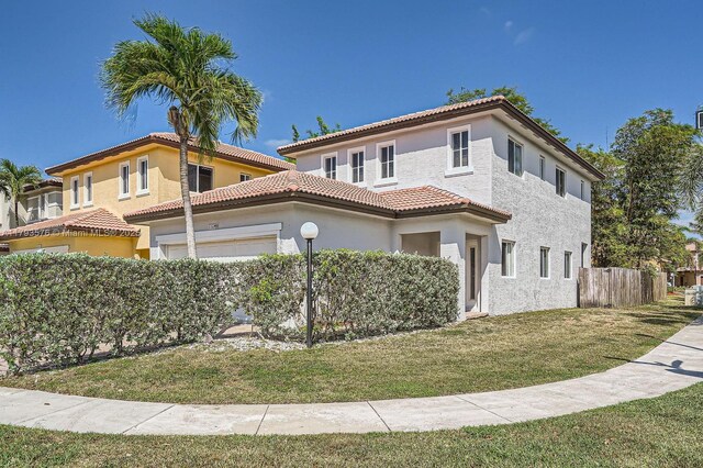1107 NE 41st Ave, Homestead, FL 33033 - mediterranean / spanish house featuring fence, a garage, stucco siding, a front yard, and a tiled roof