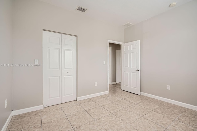 unfurnished bedroom featuring visible vents, baseboards, light tile patterned floors, and a closet