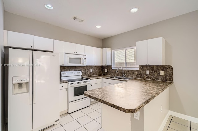 1107 NE 41st Ave, Homestead, FL 33033 - kitchen with a peninsula, dark countertops, white appliances, a sink, and light tile patterned floors