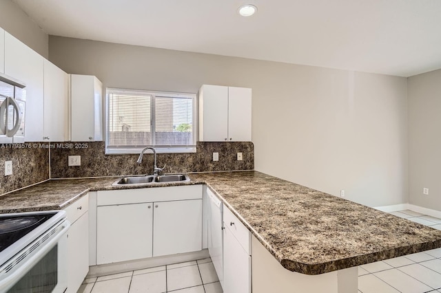 kitchen featuring a sink, light tile patterned floors, backsplash, and a peninsula