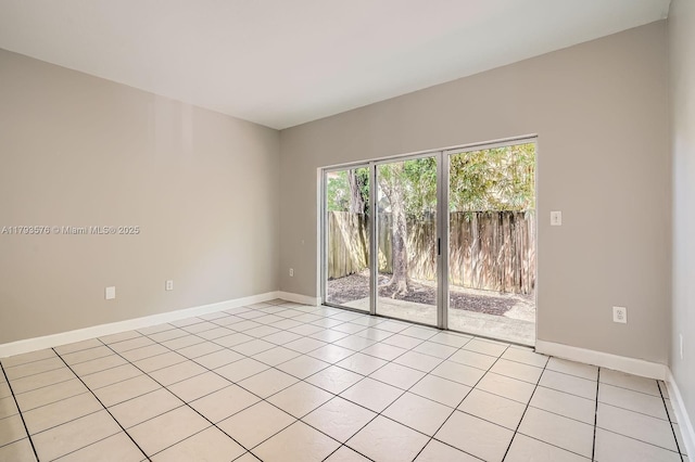 unfurnished room with light tile patterned flooring and baseboards