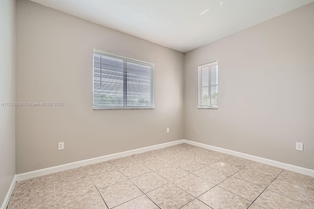 unfurnished room with baseboards and light tile patterned floors