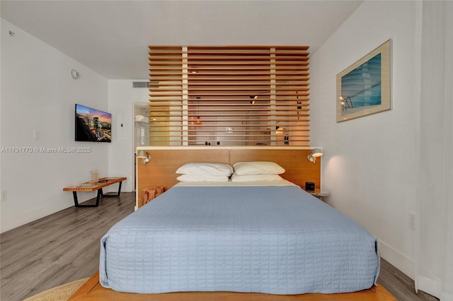 bedroom featuring visible vents and wood finished floors