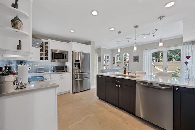 kitchen featuring ornamental molding, light countertops, white cabinets, a sink, and appliances with stainless steel finishes