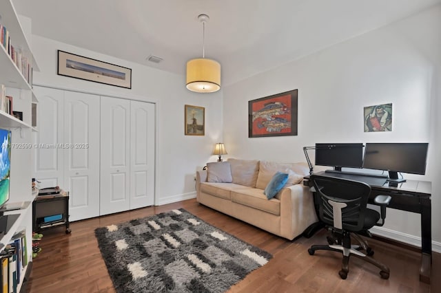 home office featuring baseboards, wood finished floors, and visible vents