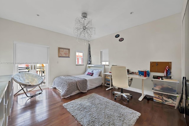 bedroom featuring an inviting chandelier and wood-type flooring