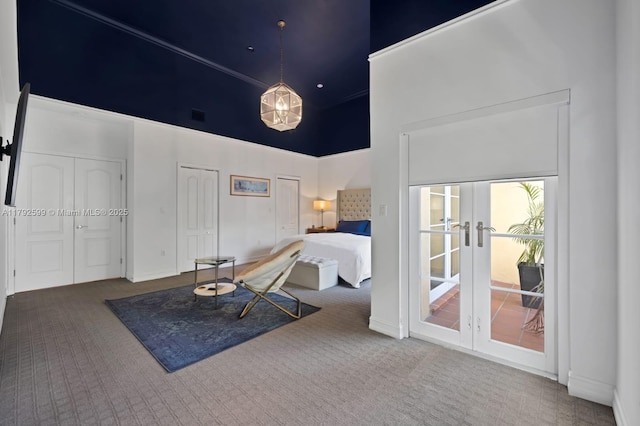 carpeted bedroom with french doors, two closets, baseboards, a towering ceiling, and visible vents